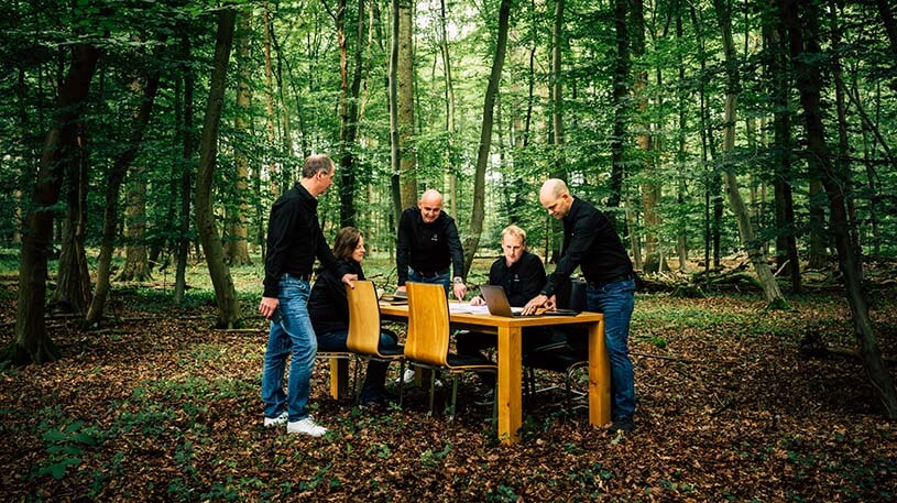 Mitarbeiter von Grimm an einem Tisch im Wald